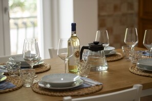 A dining table set with plates, glasses, and a wine bottle. - Cozy House Near the Ocean with Parking Space (Massa Lubrense)