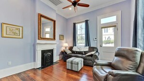 En stue med pejs, læder møbler og en loftventilator.