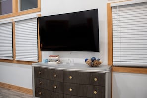 Un televisor de pantalla plana montado en la pared sobre un mueble de madera con cajones.