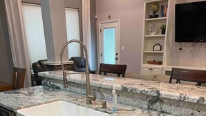 A kitchen with a granite countertop, white cabinetry, and a built-in sink. - Main House Listing 3BD/2BA

 (Edinburg)