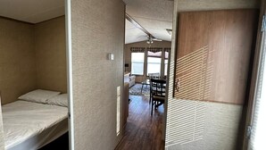 A compact room with a bunk bed, a small table, and a ceiling fan. - Beautiful Cottage (508) in Vineyards of Niagara On The Lake (Niagara-on-the-Lake)