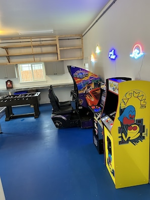 Ein Raum mit Kicker, Spielautomaten und Billardtisch.