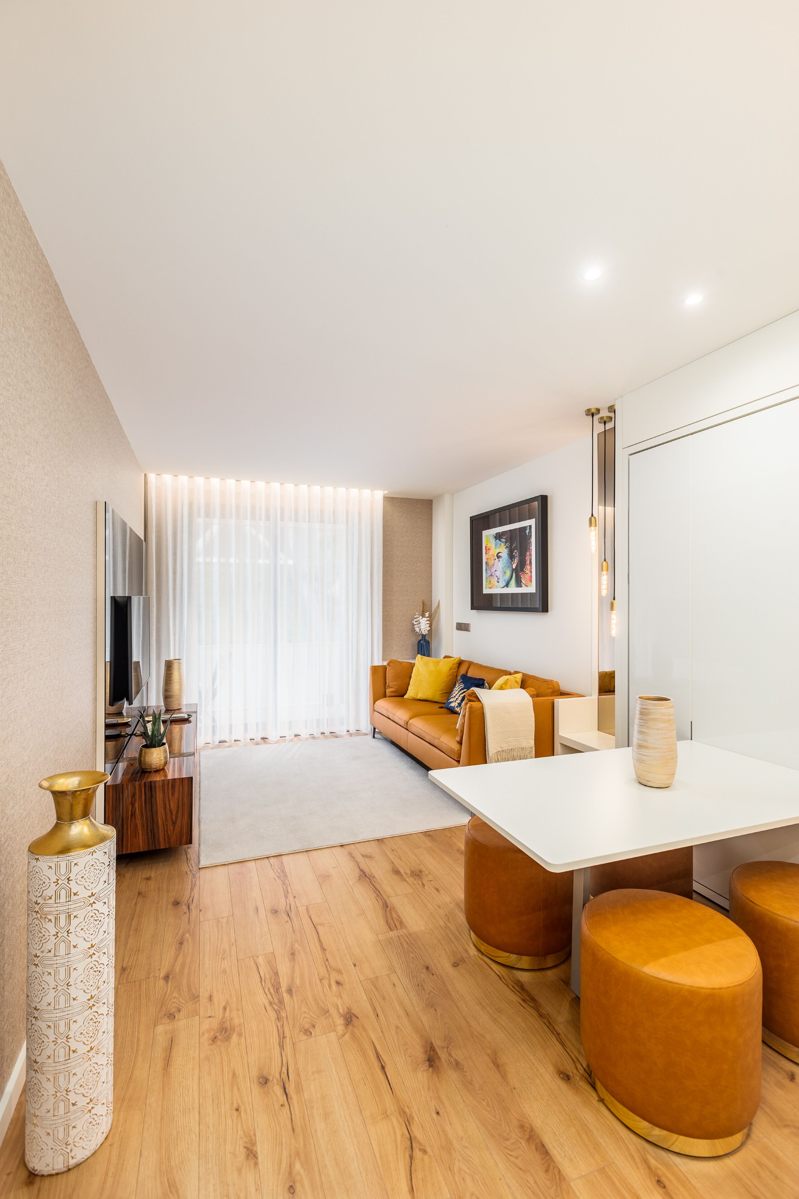 Uma sala de estar moderna com sofá, mesa de centro e pufes.