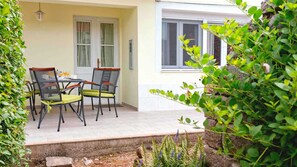 A patio with a table and chairs, a window, and a door. - Holiday house Sunshine in center of Jelsa (Jelsa)