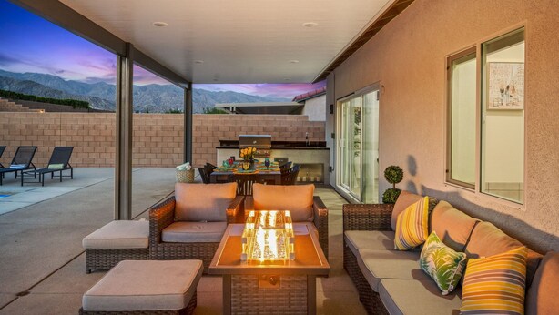 An outdoor patio with a dining table, chairs, and a sofa. - Family Paradise Saltwater Pool & Spa Game Room Fire Pit  EV Charger  Poker Table (Desert Hot Springs)