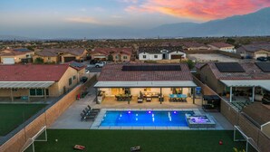 A residential area with houses, a swimming pool, and a view of distant mountains. - Family Paradise Saltwater Pool & Spa Game Room Fire Pit  EV Charger  Poker Table (Desert Hot Springs)