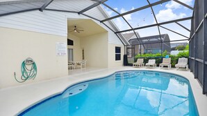 Une piscine intérieure dotée d’un ventilateur au plafond, de chaises longues et d’un panneau indiquant qu’il est interdit de plonger.
