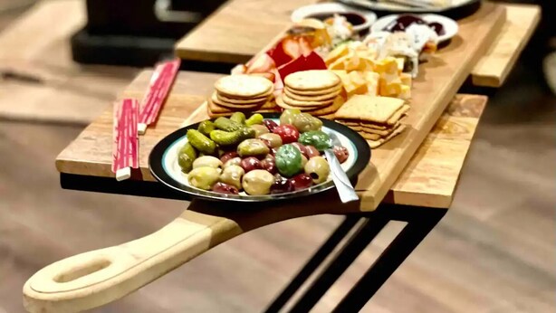 Ein Holztisch mit verschiedenen Snacks und einer Oliventeller.