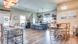 Une cuisine spacieuse avec un îlot central, des chaises en bois et une table à manger.