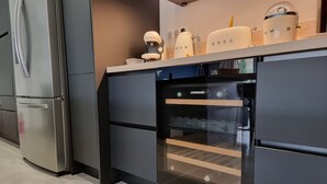 A modern kitchen with a built-in oven, a refrigerator, and a coffee machine. - Villa à 800 Mètres Cœur du Village Accessible à Pied, Secteur Sécurisé et Calme (Saint-Rémy-de-Provence)