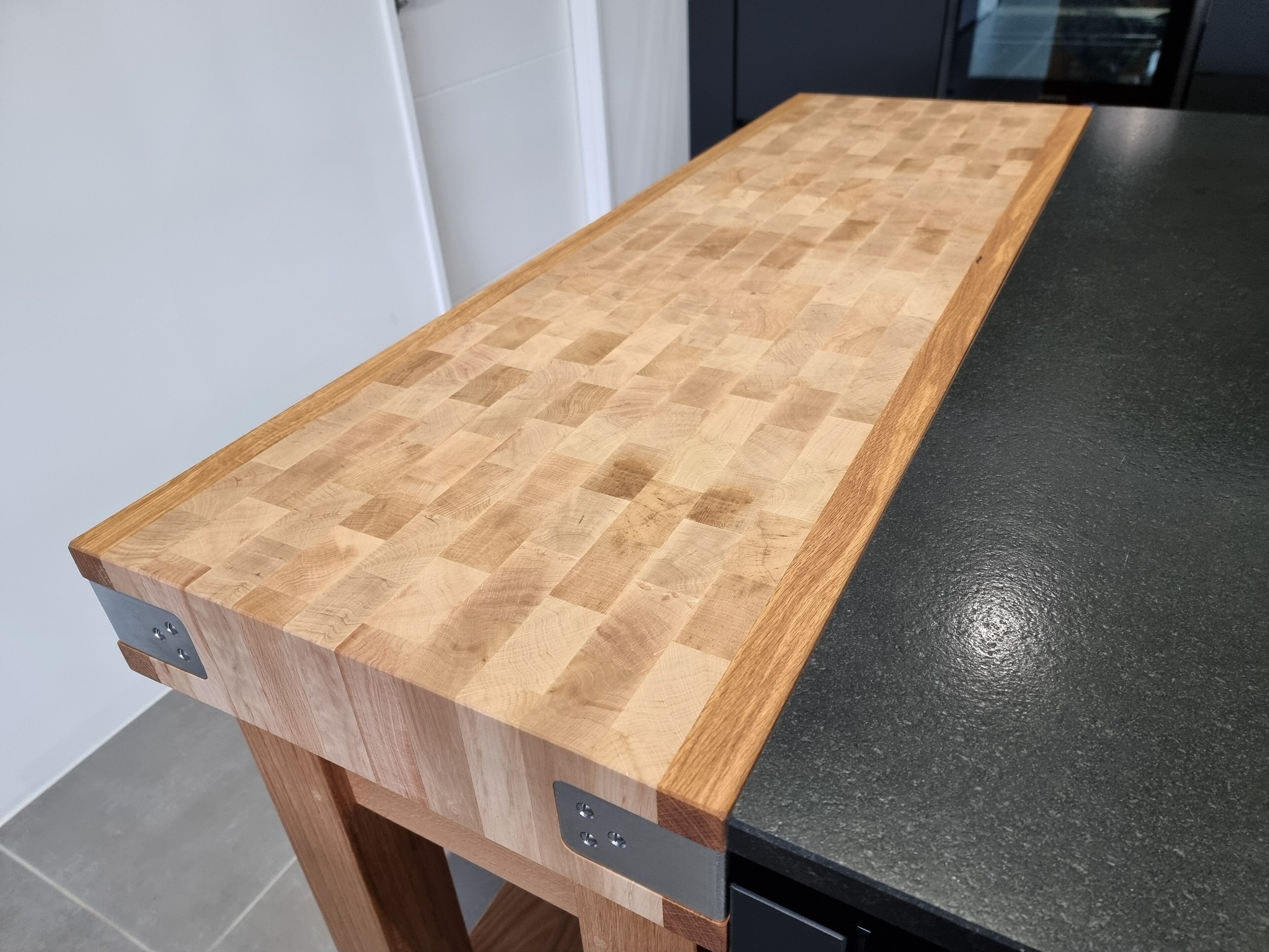 Un comptoir de cuisine avec une surface en bois et un dessus noir.
