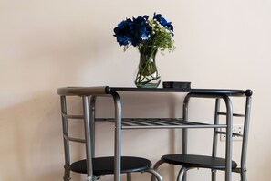 A metal stool with a vase of flowers on top. - Our split level Duplex is setup to give you an experience of home away from home (london)