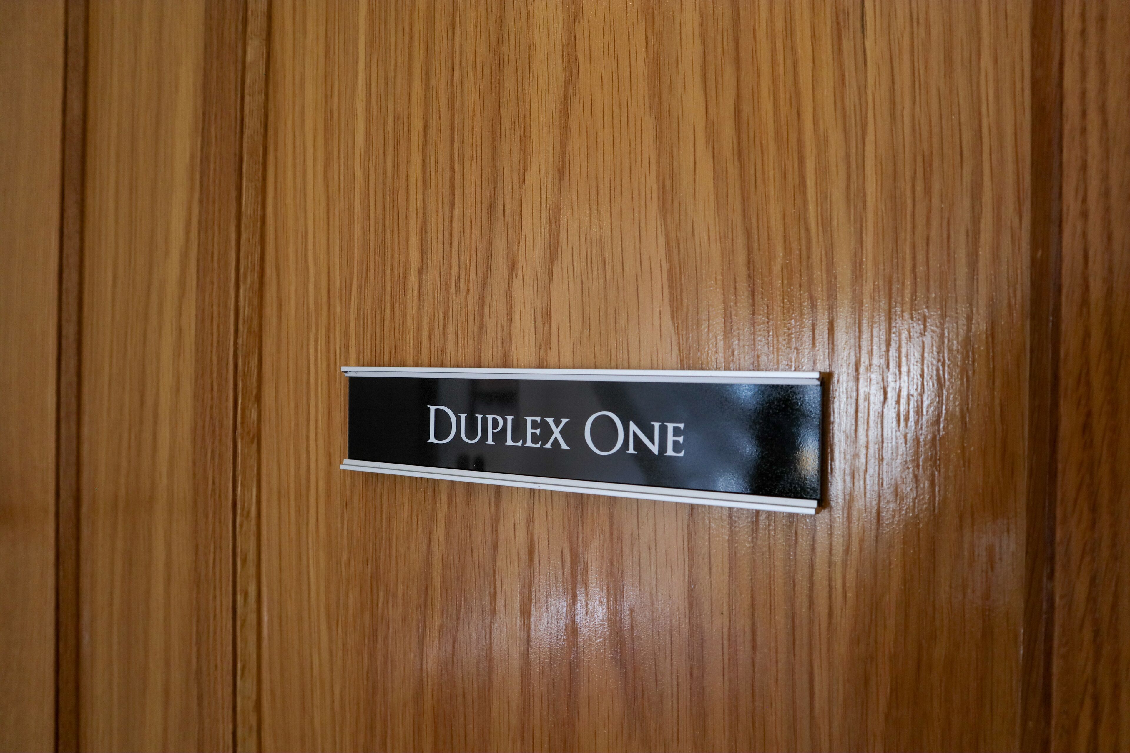 Una puerta de madera con un letrero que dice "DUPLEX ONE".