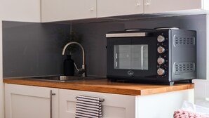 Eine Küche mit Mikrowelle, Spüle und Holzarbeitsplatte.