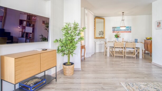 A modern living room with a wooden console, a large mirror, and a dining area with a table and chairs. - Sublime flat, city centre, modern, balconies, air conditioning, refurbished (Nice)