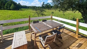 A wooden deck with a table and chairs, overlooking a green field. - Beautiful home in Vedum with kitchen (Vedum)