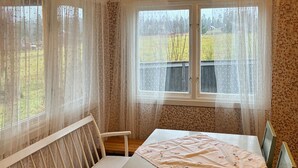 A room with a bed, a chair, a window with sheer curtains, and a view of a wooden deck and trees. - Beautiful home in Kil with WiFi (Kil)