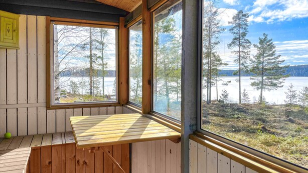 A cabin with a wooden deck and large windows overlooking a lake and forest. - Beautiful home in Kil with WiFi (Kil)