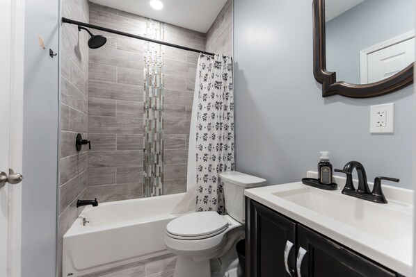 A modern bathroom with a shower, toilet, and sink.