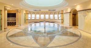 Relax in a spacious room with a central water feature and arched windows offering views of the outside.