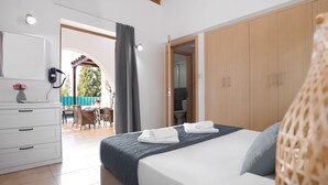 Een moderne slaapkamer met een bed, een kledingkast, een bureau en uitzicht op de buitenruimte.