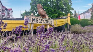 A wooden sign with 'MIECKYZDROTE' written on it, a yellow boat, and purple flowers in the foreground. - 2 bedroom amazing home in Mielno (Mielno)