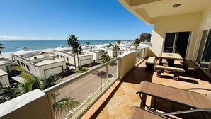 A balcony with a view of the ocean, palm trees, and other buildings. -  Welcome to Rocky Point Mexico. Enjoy the most beautiful Beach in Rocky Point . (Puerto Peñasco)