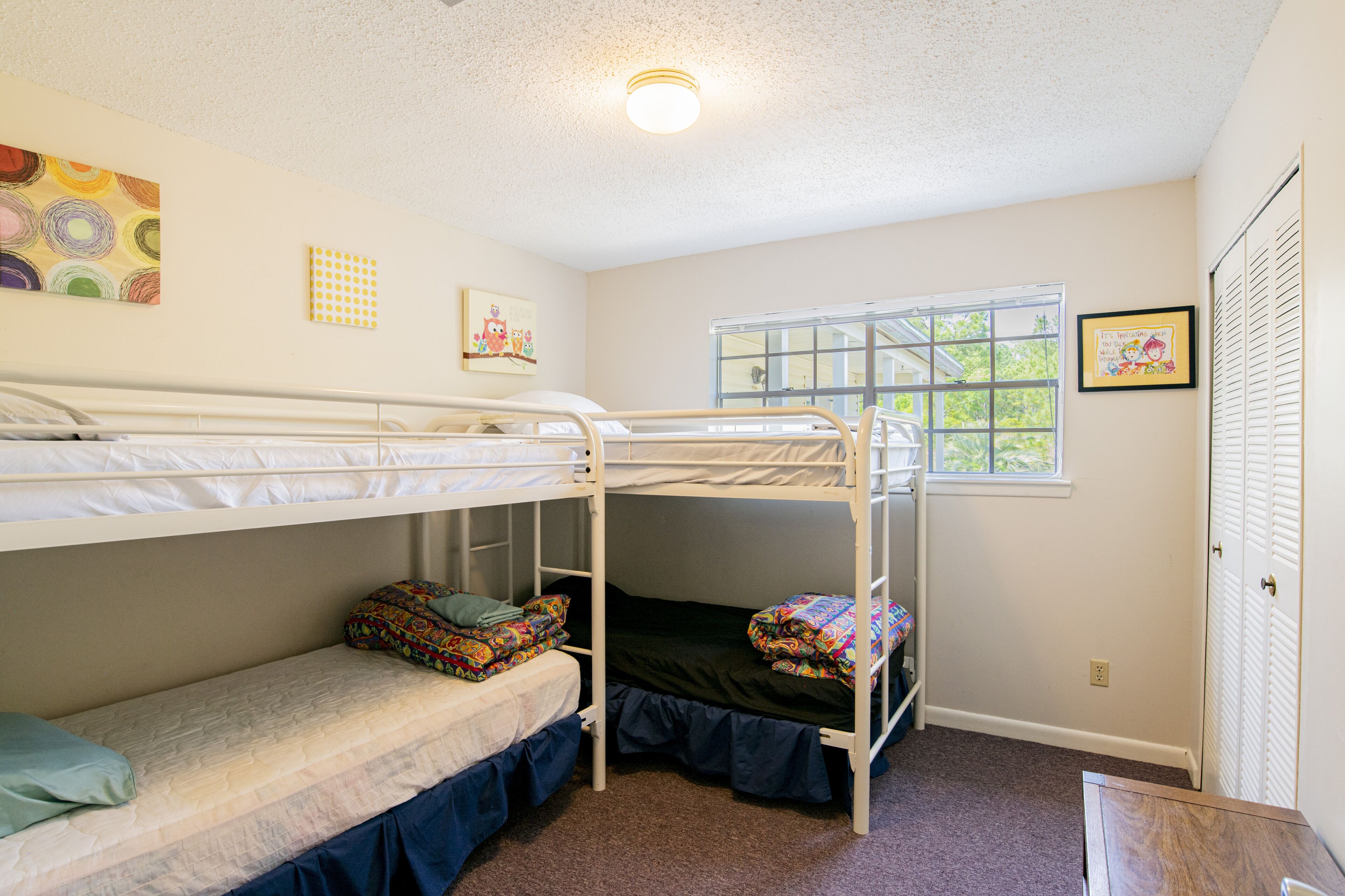 Dormitorio con literas, una ventana, una puerta y una luz en el techo.