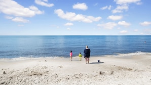 A beach scene with a clear sky and calm sea.