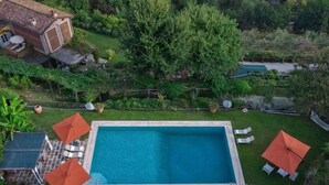 Vue aérienne d’une propriété dotée d’une piscine, d ’un espace salon extérieur et d’une végétation luxuriante.