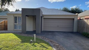 A modern single-story house with a garage, a small front yard, and a wooden fence. - Sunbury on the Park - netflix, table tennis (Sunbury)