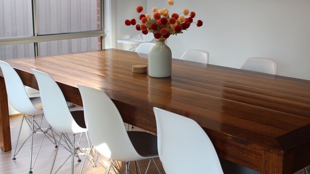 A dining table with a vase of flowers, white chairs, and a wooden floor. - Sunbury on the Park - netflix, table tennis (Sunbury)