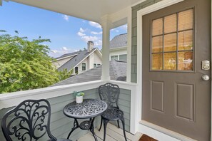A porch with a door, two chairs, and a small table with a plant. - Charming Studio Apt in Downtown Raleigh-Walkable location! (Raleigh)