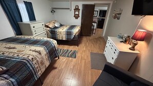 A bedroom with two beds, a dresser, a desk, and a lamp. - Rustic 2BR Fisherman’s Retreat on Douglas Lake! (Dandridge)