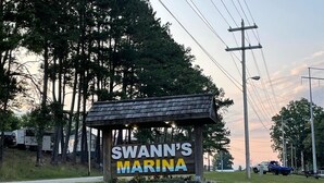 A sign for Swann's Marina with a stone base and a wooden roof. - Rustic 2BR Fisherman’s Retreat on Douglas Lake! (Dandridge)