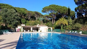 Ein Pool mit Liegestühlen und einem Gebäude im Hintergrund.