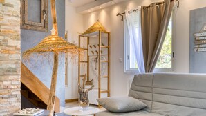 Een moderne woonkamer met een bank, een ronde tafel, een decoratieve parasol en een ladderconstructie.