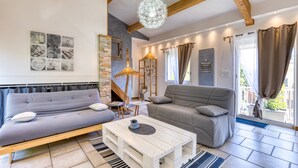 Een woonkamer met een bank, een salontafel en een open haard.