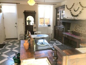 Une pièce avec un sol à carreaux, une table en bois, une chaise, un buffet et un miroir.