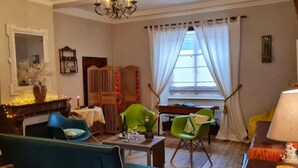 Un salon chaleureux avec une cheminée, une table à manger et deux chaises.