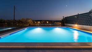 A rectangular swimming pool with a tiled edge, surrounded by a low wall and a wooden fence. - Beautiful home in Debeljak (Debeljak)