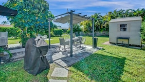 A patio with outdoor furniture, a covered seating area, and a small shed. - Stunning 2/2 dream beach getaway in Surfside (Surfside)