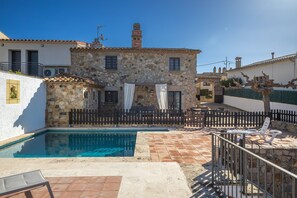 Un bâtiment en pierre doté d’une piscine, d’un espace extérieur aménagé pour s’asseoir et d’une terrasse clôturée.