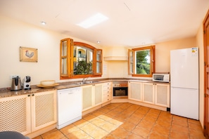 A kitchen with a dishwasher, microwave, oven, and refrigerator.