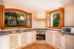 A kitchen with a built-in oven, a microwave, and a sink.