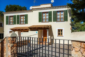A two-story building with green shutters, a tiled roof, and a stone wall. - 'Cala Pi One' with Private Terrace, Wi-Fi and Air Conditioning (Cala Pi)