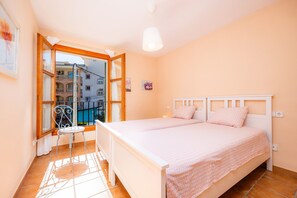 A bedroom with a bed, a chair, a window, and a view of buildings outside. - 'Cala Pi One' with Private Terrace, Wi-Fi and Air Conditioning (Cala Pi)