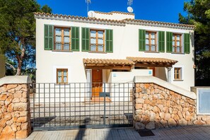 A two-story building with a stone wall entrance, green shutters, and a tiled roof. - Holiday Home 'Cala Pi Two' (Cala Pi)