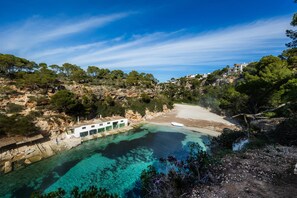 A coastal property with a clear view of the sea, a sandy beach, and a rocky cliff. - Holiday Home 'Cala Pi Two' (Cala Pi)