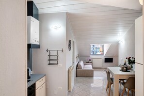 A modern kitchen with a built-in oven and a dining area with a table and chairs.